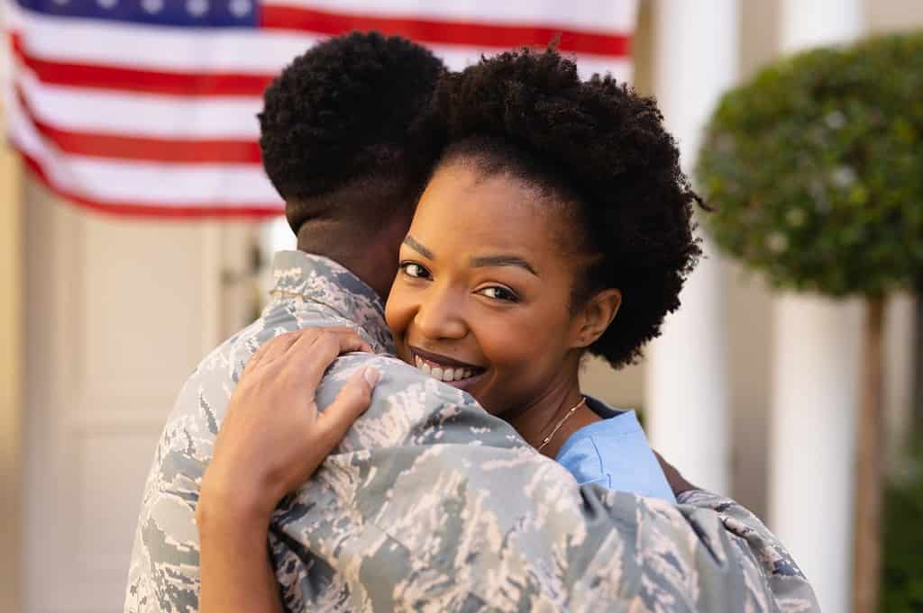 Portrait of smiling african american hugging military soldier on his return home