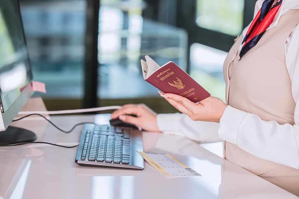 Thailand travel concept. Airline officer check in ticket tourist with Passport Visa counter service